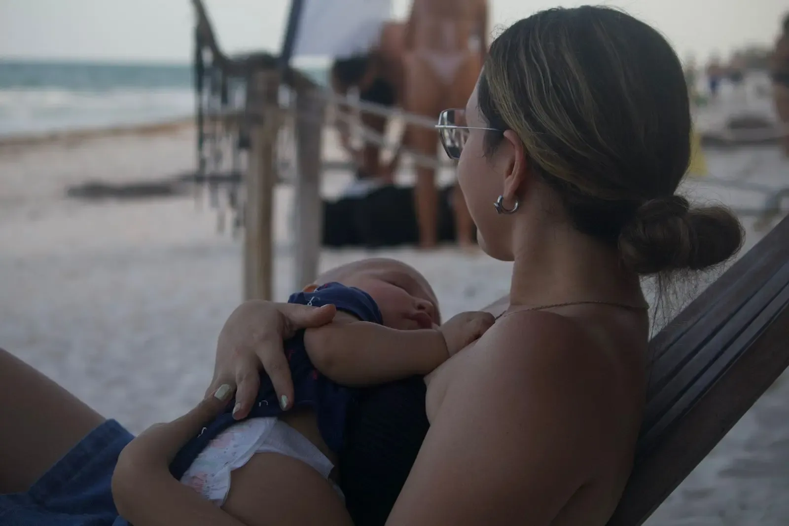 Fotografia de una madre abrazando a un bebe en la playa